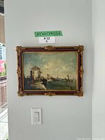 Framed painting hanging on wall with dimension tag visible