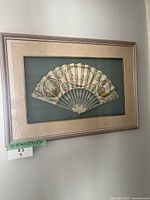 Full view of framed fan on wall