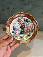 Front view showing full Imari-style decoration and gilt scalloped rim