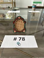 Front view of miniature micro-mosaic frame showing glass tile border and oval opening