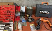 Overall lot: Ridgid drill, case, multiple bit sets, hole saws