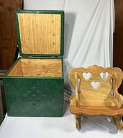 Green cube storage box open beside wooden doll rocker
