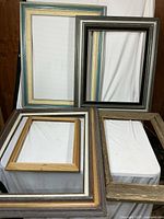 Five assorted wooden frames stacked together showing variety of colours and profiles