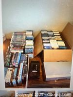 Overall view of VCR, rewinder and multiple stacks of VHS tapes on tabletop