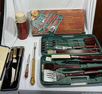 Full lot overview showing barbecue tool set, carving set, thermos, rotisserie accessory