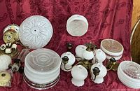 Group view of chandelier, multiple glass shades, fixture parts