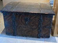 Front view of wooden trunk with iron strapping and keyhole