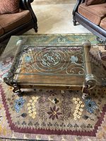 Full view showing glass top, metal scrollwork and wood frame