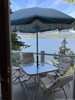Full patio set showing table, four chairs, umbrella