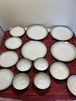 Full set of plates and bowls laid out on red cloth
