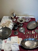 Group shot of all silver plate items, flatware and linens on table