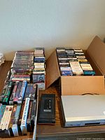 Overall lot with VCR, rewinder and VHS tapes on table