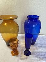 Group shot of amber vase, cobalt vase, amber goblet, cobalt bud vase
