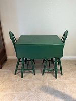 Table with leaves down and two matching chairs tucked under