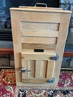 Full front view of Economy wooden ice box showing plaque, door, hardware, top handle