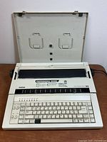 Front view with cover open showing keyboard and carriage