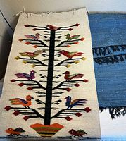 Full view of tapestry atop blue mat showing design and size