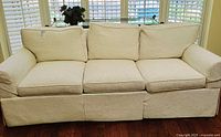 Front view of three-seat cream tuxedo sofa