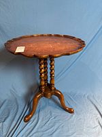 Full view of antique side table showing pie-crust top, barley-twist supports and tripod legs