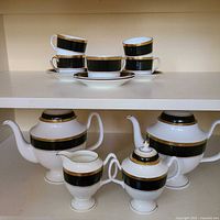 Full set on shelves showing cups, saucers, coffee pots, creamer and sugar bowl
