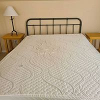 Full view of mattress with foam topper and metal headboard