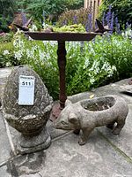 Group shot of metal bird bath, stone pig planter, stone pinecone statue