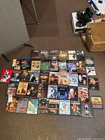 Overhead view showing roughly forty DVD and Blu-ray titles laid out on carpet