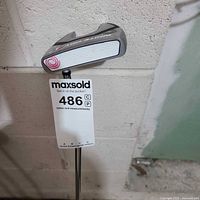 Face and toe side of Odyssey White Hot RX V-Line Fang putter showing white insert and pink logo