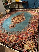 Full view of blue Kerman rug with central medallion and borders