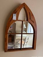 Front view of gothic arch pine wall mirror hung on wall