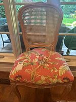 Front view of cane-back chair showing overall design, cane panel and upholstered seat