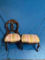 Chair and footstool full view against blue backdrop