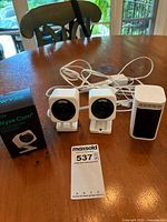 Three Wyze cameras and box on table