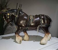 Left side view of porcelain Shire horse with leather harness and chains