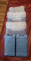 Two blue Coleman chillers in front of three Cryopak packs stacked