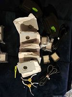 All accessories laid out: dust bags, dust bins, filters, cords, side brushes, cleaning tool