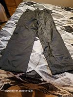 Grey nylon outer side of reversible snow pants displayed flat