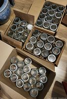 Four boxes containing dozens of Crown jars with metal rings