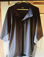 Front view of black Ping rain jacket showing overall design, 3⁄4 sleeves and elastic hem