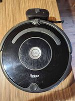 Top view of iRobot Roomba showing Clean button and charging dock