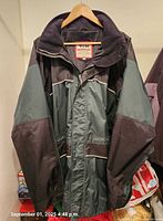 Front view of Viking dark green/black hooded coat on hanger
