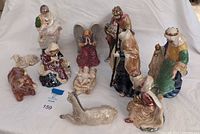 All 11 glazed ceramic nativity figurines arranged on white backdrop