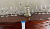 Full set displayed on dresser showing clock centered between two decanters and four goblets on each side