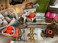 overview of yarn skeins, needles, books, frame and glue gun