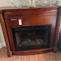 Front view of electric fireplace showing wood mantel, firebox insert, and fluted columns