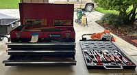 Toolbox open with drawers, Vise-Grip packages visible, plastic mechanic set beside
