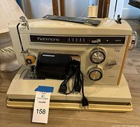 Front view of Kenmore sewing machine on base with foot pedal and cord