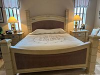 Front view of assembled king bed frame showing headboard, footboard, upholstered panels, corner posts