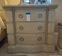 Front view of one nightstand showing drawers, hardware, finish and carved details