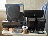 Front view of receiver with subwoofer, speakers, wire, plugs, remote